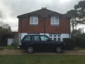 a black car parked in front of a house