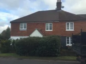 a red brick house with a black truck parked in front of it