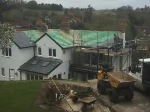 a construction site with a tractor and a house in the background