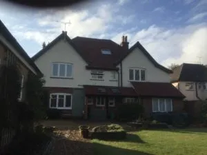 a large white house sitting next to a lush green field